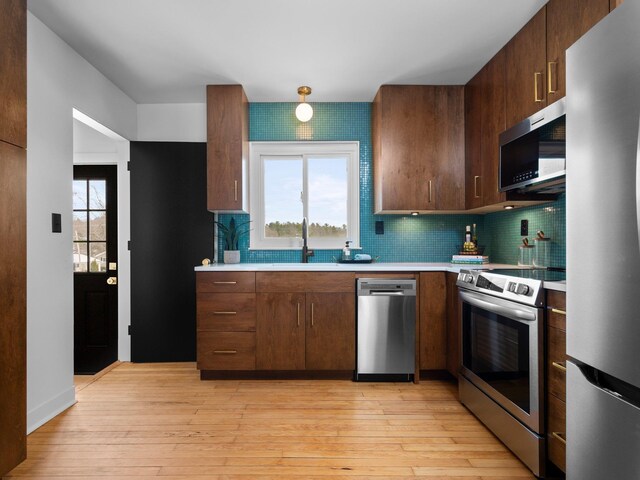 1330 N Orchard Dr, Traverse City, MI 49686 - kitchen featuring appliances with stainless steel finishes, a sink, light countertops, and backsplash