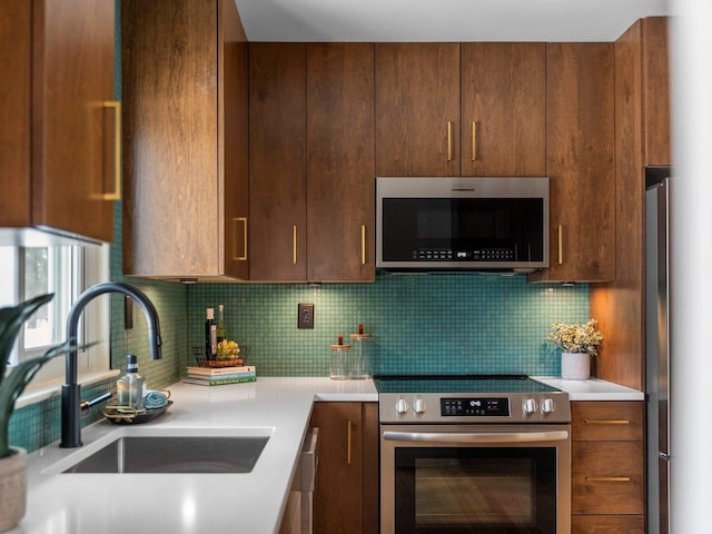 1330 N Orchard Dr, Traverse City, MI 49686 - kitchen with stainless steel appliances, a sink, light countertops, tasteful backsplash, and dark brown cabinetry