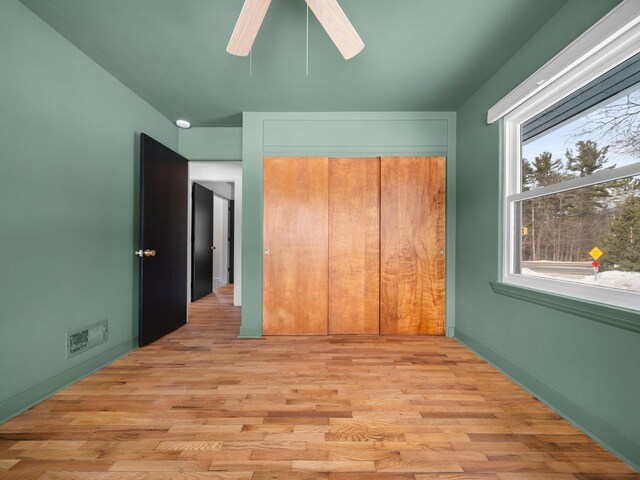 1330 N Orchard Dr, Traverse City, MI 49686 - unfurnished bedroom with light wood-style floors, a closet, and a ceiling fan