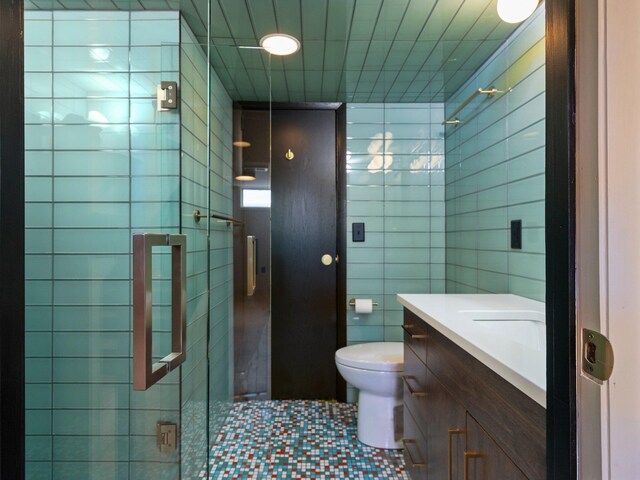 1330 N Orchard Dr, Traverse City, MI 49686 - bathroom with tile walls, vanity, toilet, and tile patterned floors