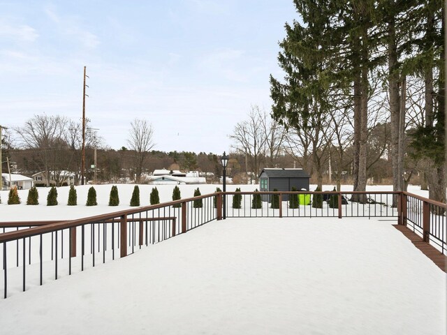 1330 N Orchard Dr, Traverse City, MI 49686 - snow covered deck with an outbuilding, a storage unit, and fence