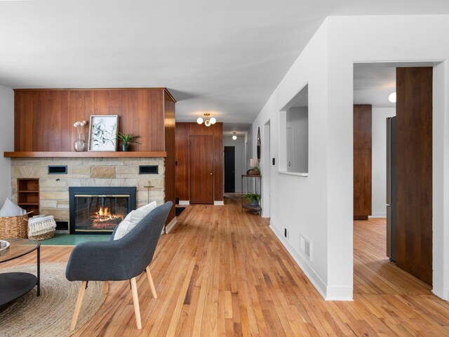 1330 N Orchard Dr, Traverse City, MI 49686 - living room with light wood-style flooring, a stone fireplace, and baseboards