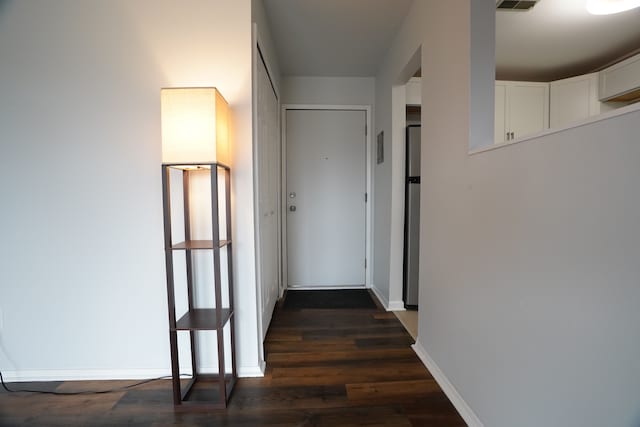 hallway featuring dark wood-style floors and baseboards