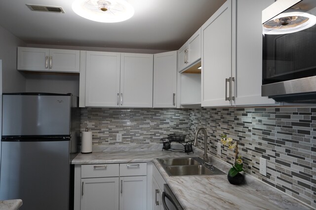 32013 W 12 Mile Rd Unit 306, Farmington Hills, MI 48334 - kitchen with appliances with stainless steel finishes, a sink, light countertops, tasteful backsplash, and white cabinets