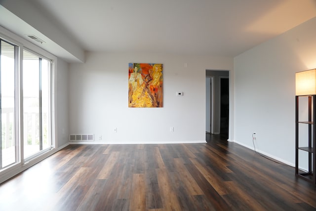 empty room with dark wood finished floors and baseboards