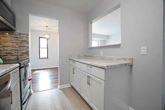 kitchen with stainless steel appliances, backsplash, plenty of natural light, and light wood finished floors