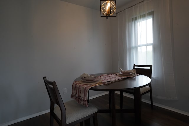 dining room featuring baseboards, a chandelier, and dark wood-type flooring