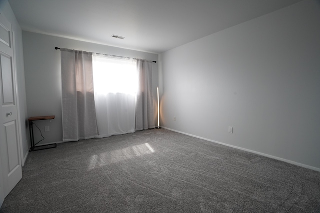 carpeted empty room with baseboards