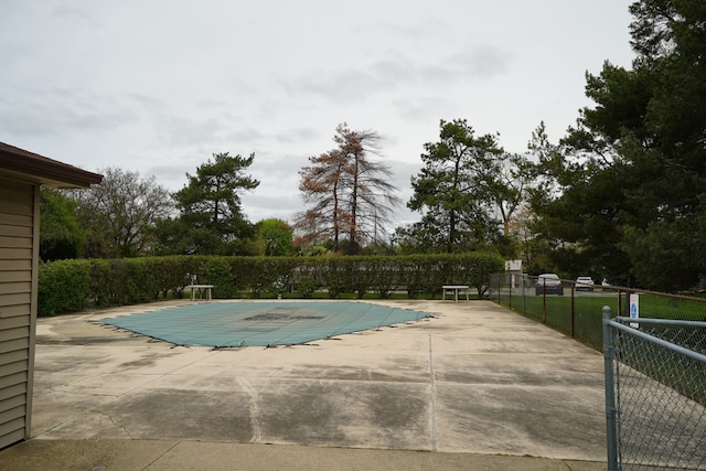 community pool with fence and a patio