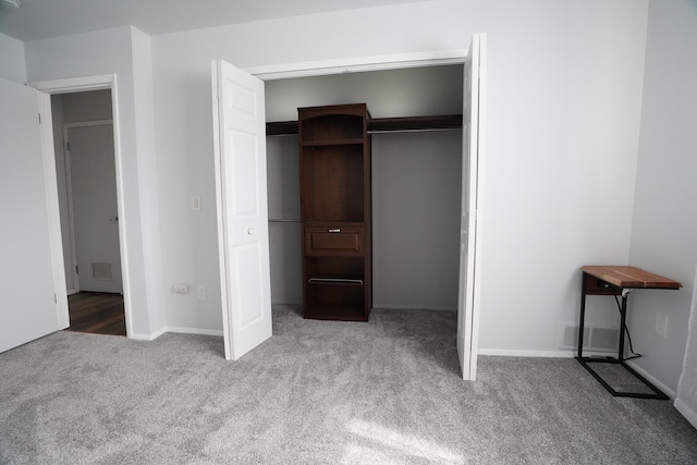 unfurnished bedroom featuring carpet, a closet, and baseboards