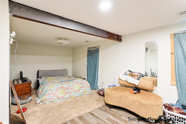bedroom featuring wood finished floors and beam ceiling
