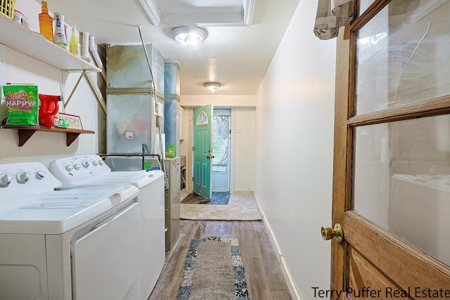 laundry room with wood finished floors, washer and dryer, and baseboards