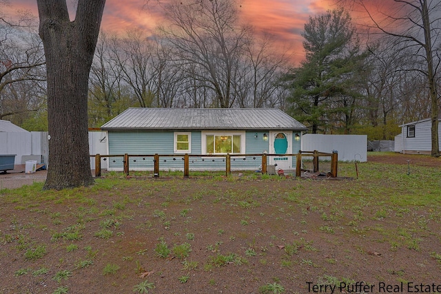 back of property featuring metal roof and fence
