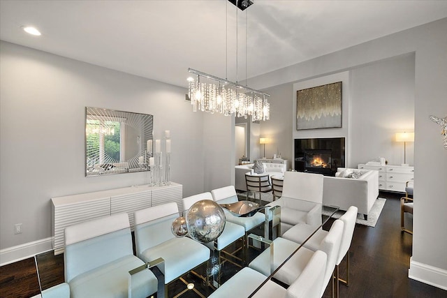 31080 Lucerne Dr, Franklin, MI 48025 - dining space with a glass covered fireplace, baseboards, dark wood finished floors, recessed lighting, and a chandelier