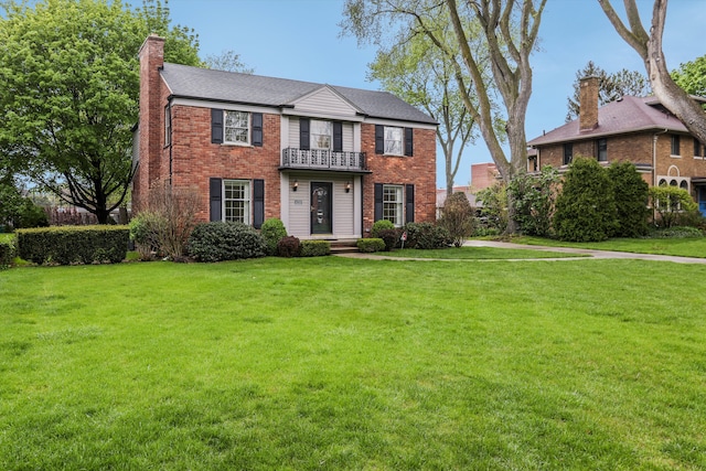 1133 Balfour St, Grosse Pointe Park, MI 48230 - colonial house with a balcony, a chimney, brick siding, and a front yard
