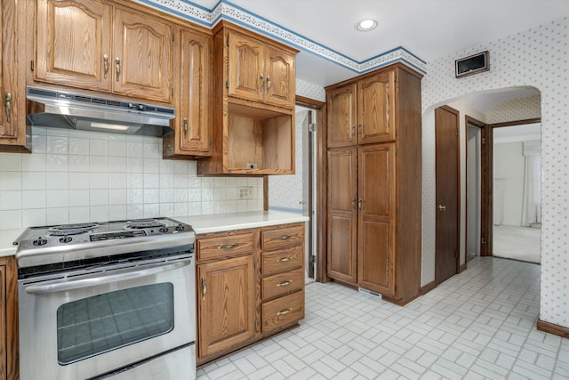 1133 Balfour St, Grosse Pointe Park, MI 48230 - kitchen featuring stainless steel range with electric cooktop, wallpapered walls, under cabinet range hood, brick patterned flooring, and light countertops
