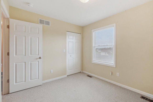 unfurnished bedroom featuring carpet floors, baseboards, and a closet