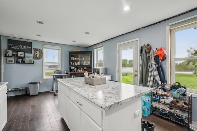 kitchen with white cabinetry, dark wood finished floors, a center island, recessed lighting, and light stone counters