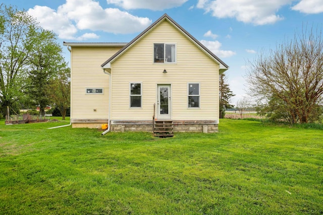 rear view of house with entry steps and a lawn