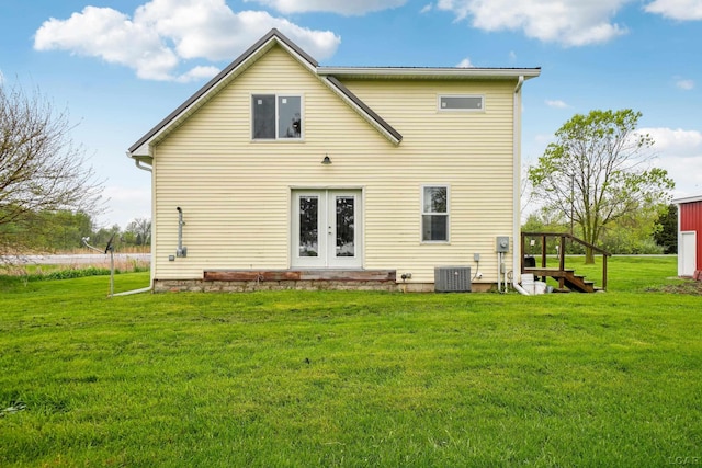 rear view of property with central AC unit, a lawn, french doors, and stairway
