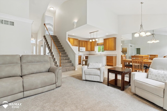 4433 Sunset Blvd, Grand Blanc, MI 48439 - living room with high vaulted ceiling, a chandelier, stairway, light carpet, and recessed lighting