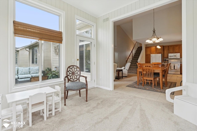 4433 Sunset Blvd, Grand Blanc, MI 48439 - sitting room featuring a chandelier, stairs, light colored carpet, baseboards, and light tile patterned floors