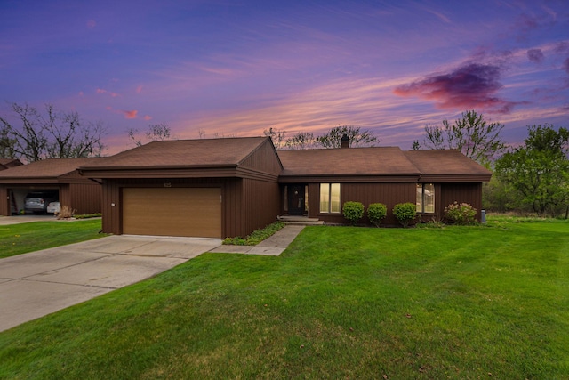 view of front of home featuring an attached garage, a front lawn, and concrete driveway