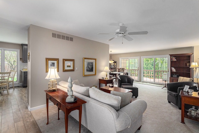 living area featuring healthy amount of natural light and ceiling fan