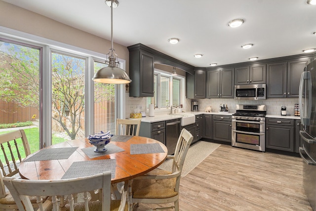 kitchen featuring stainless steel appliances, gray cabinetry, healthy amount of natural light, and decorative backsplash