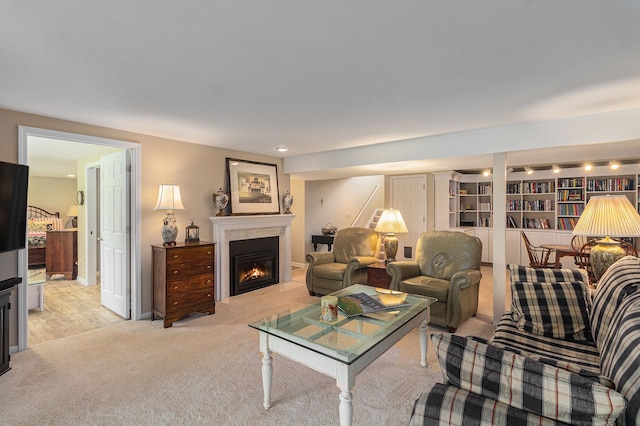 living area with a glass covered fireplace and light colored carpet