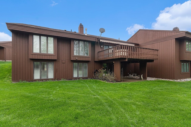rear view of property featuring a lawn and a deck