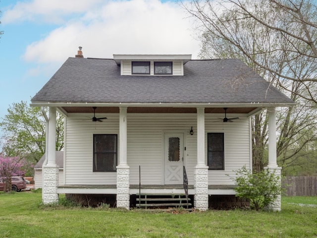 bungalow with ceiling fan, a porch, a chimney, and a shingled roof