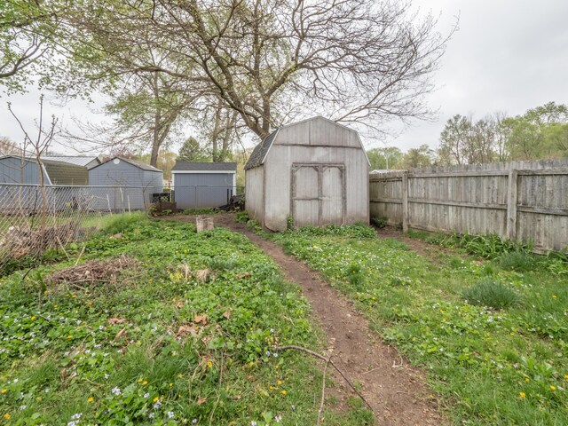 fenced backyard with a storage unit and an outdoor structure