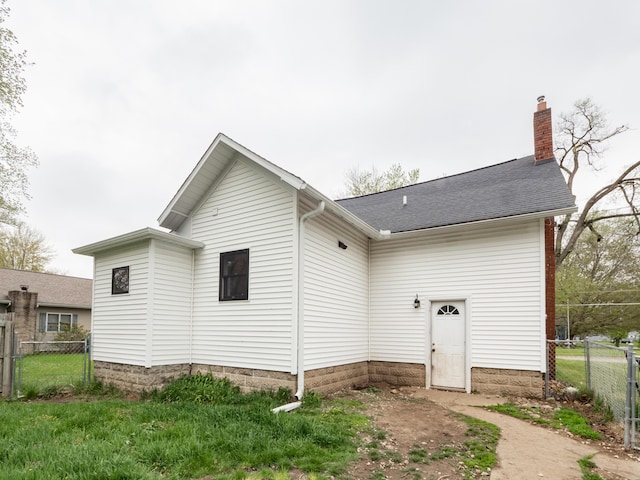 back of property with a chimney and fence
