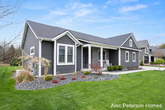 view of front of home featuring covered porch, a front yard, and roof with shingles