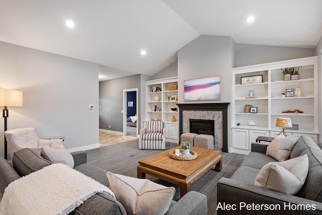 living area featuring vaulted ceiling, a glass covered fireplace, recessed lighting, and baseboards
