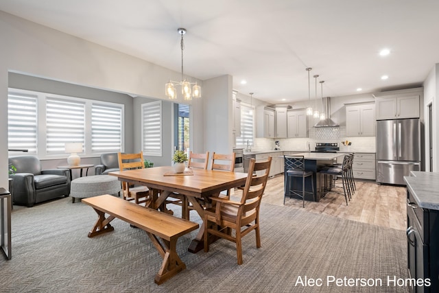 dining area with a chandelier, recessed lighting, and light wood finished floors