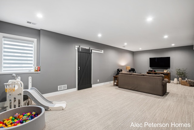 carpeted living area featuring a barn door, recessed lighting, and baseboards