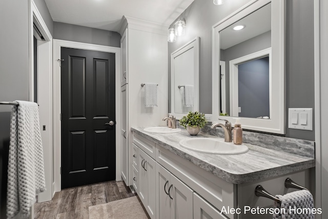 bathroom with double vanity and wood finished floors