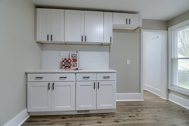 127 Bates St, Jackson, MI 49202 - kitchen with baseboards, decorative backsplash, light countertops, and white cabinets