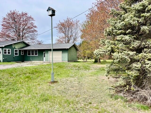 view of grassy yard with a garage