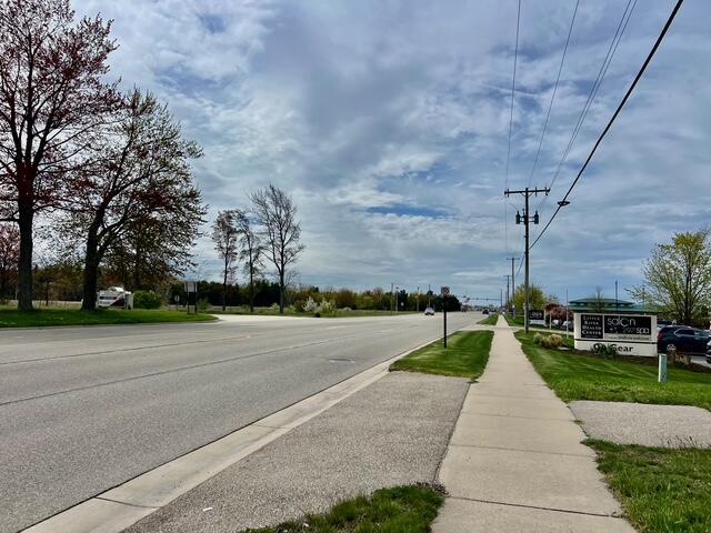 view of asphalt road with sidewalks