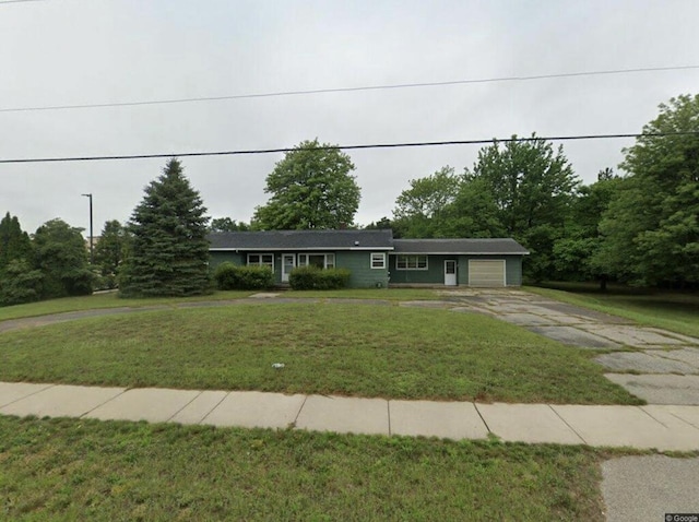 ranch-style house featuring driveway, an attached garage, and a front yard