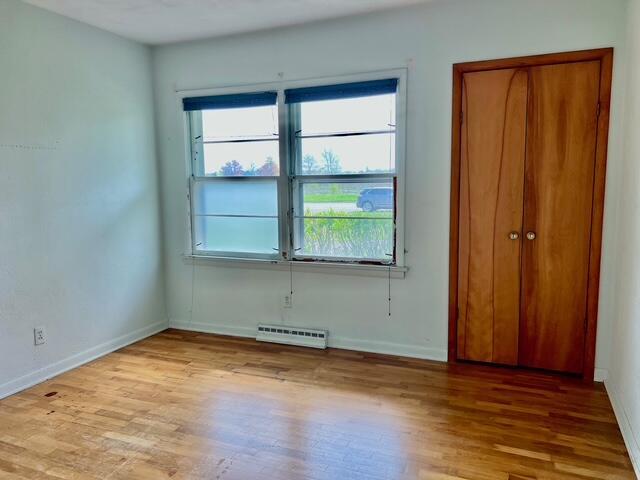 unfurnished bedroom with wood finished floors and baseboards