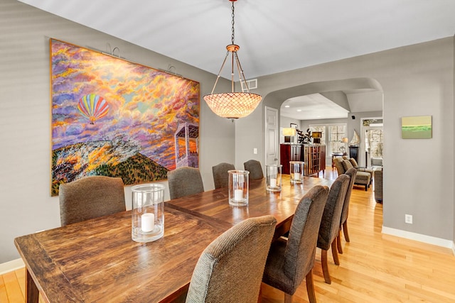 2700 Deep Forest Way, Fennville, MI 49408 - dining area featuring arched walkways, light wood-style flooring, and baseboards