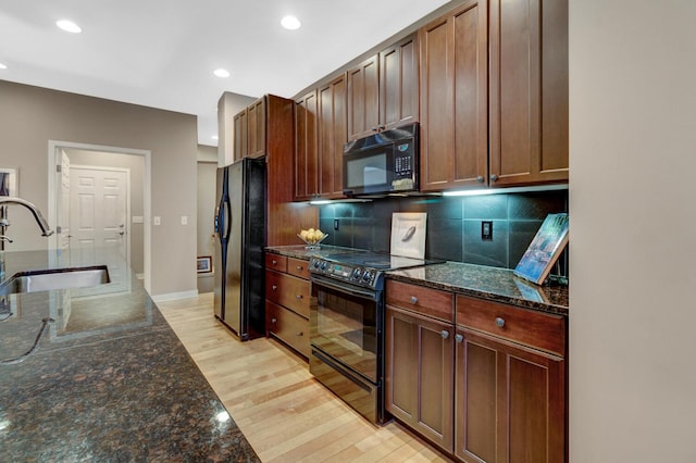 2700 Deep Forest Way, Fennville, MI 49408 - kitchen with black appliances, a sink, light wood-style flooring, decorative backsplash, and dark stone counters