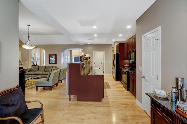 2700 Deep Forest Way, Fennville, MI 49408 - kitchen featuring black appliances, arched walkways, light wood-type flooring, dark brown cabinets, and recessed lighting