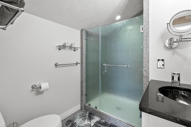 full bath with toilet, a stall shower, a textured ceiling, and vanity
