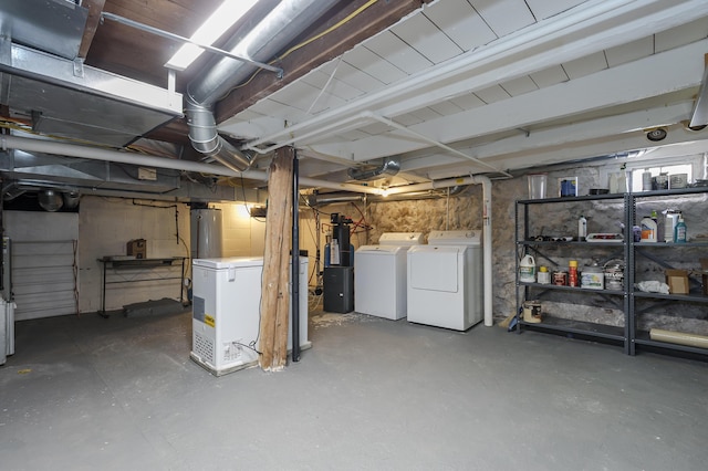 unfinished basement featuring washer and clothes dryer, fridge, and water heater