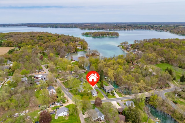 aerial view of property's location with a large body of water and a forest
